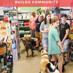 A lively in-store retail event with shoppers browsing, engaging with products, and a store owner welcoming customers, creating a strong community vibe.