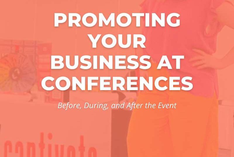 A small business owner standing behind a branded vendor table at a conference, engaging with attendees and handing out marketing materials.
