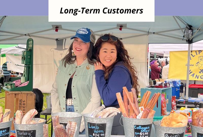 A vibrant in-person retail event where a small business owner connects with attendees to build relationships and drive long-term growth